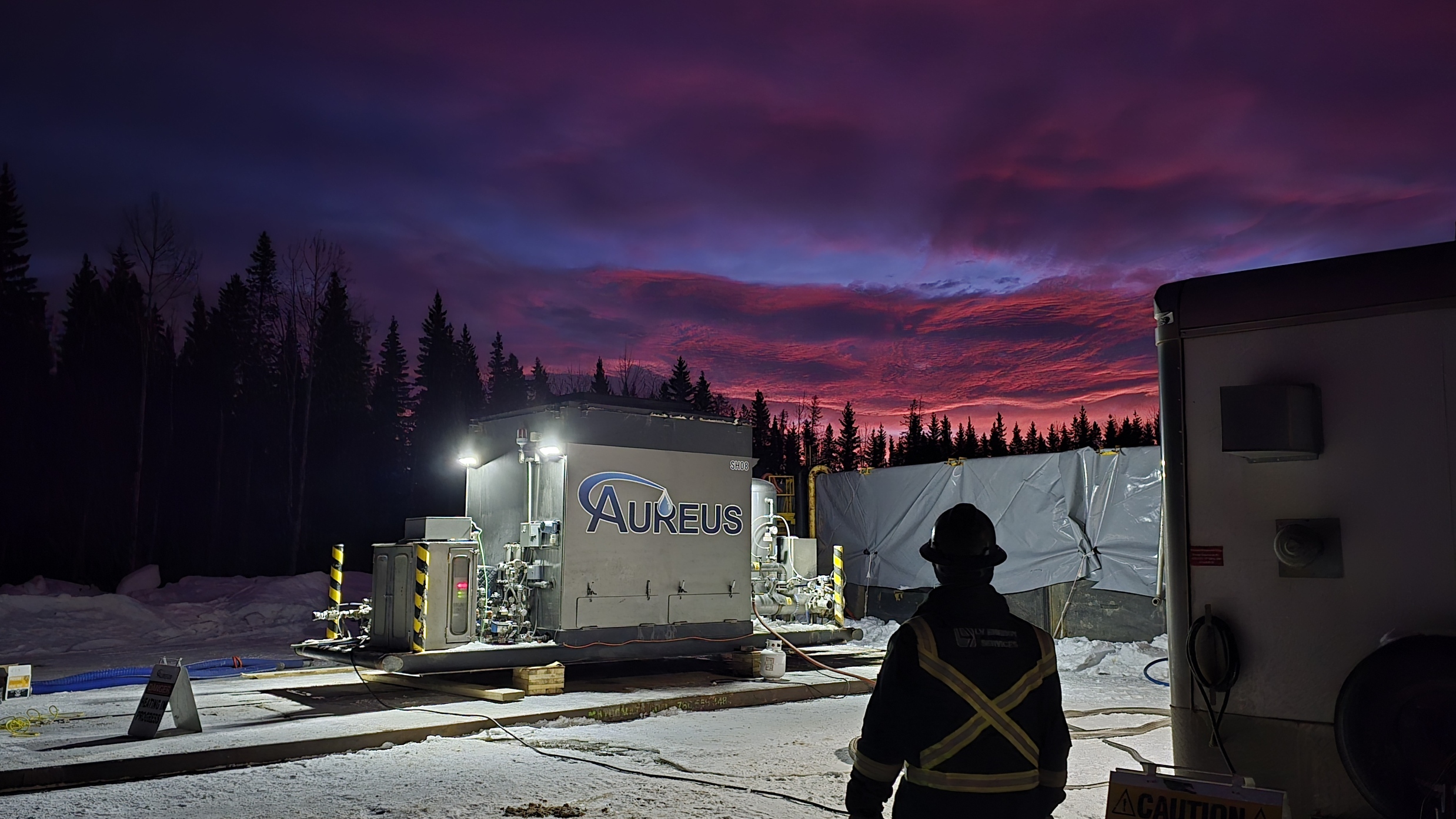 An image of a 40MIL btu super heater, cring and a shilloutte of a worker with a beautiful pink and purple sunset in the background
